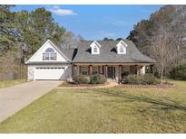 Charming single-story home with brick and siding exterior, well-manicured lawn, and attached garage at 950 Besse Way, Locust Grove, GA 30248