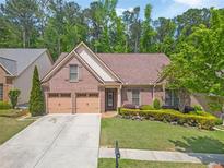 Charming brick home with well-manicured landscaping and a two-car garage at 1867 Willoughby Dr, Buford, GA 30519