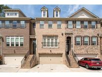 Charming brick townhome with attached garage and inviting front entrance, offering a blend of classic design and modern living at 2122 Pembroke Dr, Brookhaven, GA 30319