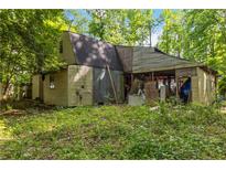 Rustic home exterior with tan siding, dark roof, and open-air structure at 4250 Deerfield Rd, Cumming, GA 30028