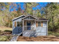 Charming single-story home featuring a cozy front porch and a well-maintained, wooded front yard at 1786 Richard Ne Rd, Conyers, GA 30012