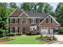 Beautiful brick two-story home featuring a manicured lawn, mature landscaping, and a two-car garage at 3106 Soldier Trl, Marietta, GA 30068