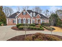 Elegant brick home with manicured landscaping and circular driveway at 5560 Stoneleigh Dr, Suwanee, GA 30024