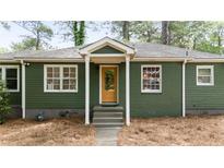 Charming green home featuring a bright yellow front door and white trim accents at 720 Maynard Se Ter, Atlanta, GA 30316