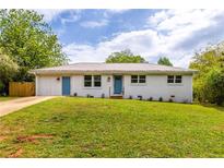 Charming single-story home with a metal roof, fresh white paint and vibrant blue doors and trim at 1755 Rockbridge Nw Rd, Conyers, GA 30012