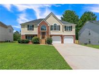 Inviting two-story home with a well-manicured lawn and two-car garage at 5452 Sweetsprings, Powder Springs, GA 30127