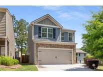 Charming two-story home with a two-car garage and a combination of brick and siding exterior at 3406 Pennington Dr, Lithonia, GA 30038