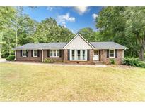 Charming single-story brick home featuring a well-manicured lawn and a classic design with black shutters at 150 Newton Ridge Dr, Covington, GA 30014