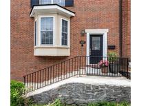 Charming brick home featuring a bay window, black door, and inviting front entrance with manicured landscaping at 1634 Ponce De Leon Ave # 107, Atlanta, GA 30307