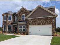 Two-story home with brick facade and a two car garage, as well as manicured landscaping at 306 Rodeo Dr, Auburn, GA 30102