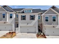 Charming townhome featuring a clean white facade, two-car garage and decorative shutters at 1297 Fern Ridge Ct # 24, Norcross, GA 30093