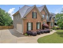 Charming brick two-story home features a manicured lawn, walkway, and two-car garage at 3641 Carriage Glen Way, Dacula, GA 30019