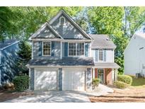 Charming two-story home with a two-car garage, fresh landscaping, and delightful blue shutters at 3253 Strathmore Dr, Duluth, GA 30096