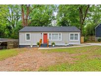 Charming single-story home with a fresh gray exterior, bright orange door, and well-maintained landscaping at 3566 Orchard Dr, Decatur, GA 30032