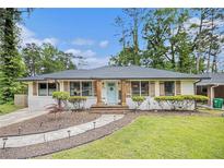 Charming single-story home featuring a landscaped yard, inviting walkway, and a delightful, light blue front door at 2779 Fairlee Dr, Decatur, GA 30032