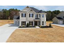New construction home with light gray brick, shutters, manicured landscaping, and a side entry garage at 3154 Rosebud Rd, Loganville, GA 30052