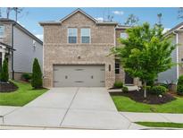 Charming two-story brick home with a well-manicured front yard and an attached two-car garage at 4777 Waxwing St, Hoschton, GA 30548