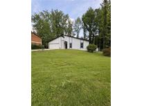 Exterior view of house with a green lawn and big trees in front of the property at 3285 Rollingbrook Way, Duluth, GA 30096