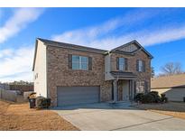 Two-story brick home with attached garage and well-maintained lawn under a bright sky at 8484 Glenview St, Douglasville, GA 30134