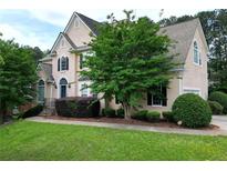 Charming two-story home featuring a well-manicured lawn and beautifully landscaped front yard at 1035 Eagles Brooke Dr, Locust Grove, GA 30248