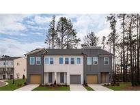 Modern townhouse exteriors with a neutral color palette, attached garages, and well-maintained landscaping at 1722 Gunnin Nw Trce # 233, Atlanta, GA 30318