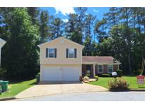 Charming home with a two-car garage, well-maintained lawn, and beautiful landscaping at 3102 Aberdeen Cv, Lithonia, GA 30038