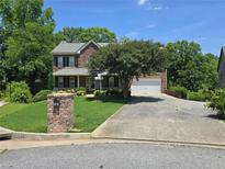 Charming two-story brick home with a well-manicured lawn and inviting curb appeal at 345 Oak Springs Nw Dr, Lawrenceville, GA 30043