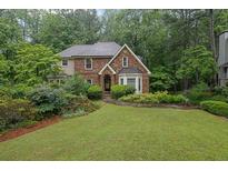 Charming brick home featuring a lush green lawn and mature landscaping at 842 Laurel Crest Sw Ct, Marietta, GA 30064
