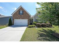 Charming home featuring a brick facade, manicured lawn, and a two-car garage at 2209 Cedar Place Ct, Snellville, GA 30078