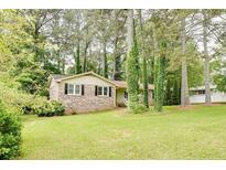 Charming brick home with black shutters and a well-maintained lawn surrounded by mature trees at 2621 Manor Pl, Ellenwood, GA 30294