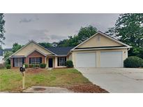 Inviting single Gathering home featuring a two-car garage and manicured front lawn at 1229 Huntington Place Cir, Lithonia, GA 30058