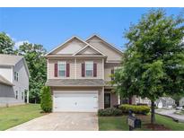 Charming two-story home with a well-manicured front yard and a two-car garage at 345 Lara Ln, Mcdonough, GA 30253