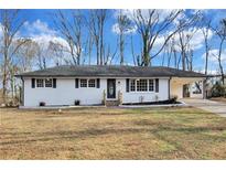 Charming, freshly painted one-story home with a well-maintained lawn, a carport, and stylish black shutters at 5774 Forest Dr, Acworth, GA 30102