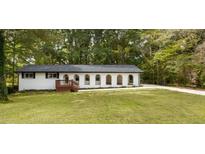 Charming single story home featuring white painted brick, arched windows, and a spacious front yard at 1019 Crestwood Ln, Stone Mountain, GA 30087