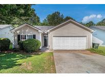 Charming single-Gathering home featuring a two-car garage and a well-manicured front lawn at 9188 Jefferson Village Sw Dr, Covington, GA 30014
