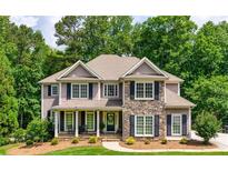 Charming two-story home featuring a stone facade and well-manicured front yard, surrounded by mature trees at 255 Ashmere Ct, Tyrone, GA 30290