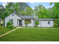 Charming bungalow with a freshly manicured lawn and meticulously maintained landscaping at 1712 Venetian Sw Dr, Atlanta, GA 30311