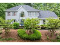Charming two-story home with a well manicured landscaped front yard and classic architectural details at 4433 Windsor Oaks Cir, Marietta, GA 30066