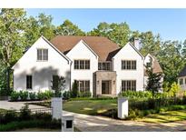 Stunning white brick home featuring a manicured lawn and elegant black wrought iron fence at 490 Mount Paran Rd, Atlanta, GA 30327