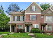 Traditional townhome with brick and vinyl siding, covered entrances, and well-maintained landscaping at 4670 Ernest Dr, Forest Park, GA 30297