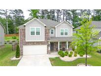 Charming two-story home featuring a brick facade, covered porch, and well-manicured front yard at 688 Saffron Blvd, Lawrenceville, GA 30045