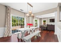 Bright dining area featuring hardwood floors, a white table with benches, and sliding glass doors to the backyard at 5010 Foxberry Ln, Roswell, GA 30075