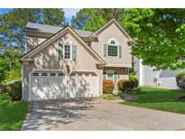 Charming home with a two-car garage, neutral paint, green shutters, and well-manicured landscaping at 5010 Foxberry Ln, Roswell, GA 30075