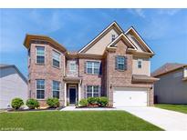 Charming two-story brick home featuring manicured landscaping, a two-car garage, and a welcoming front entrance at 205 Kestrel Cir, Covington, GA 30014