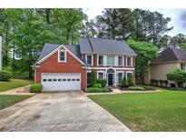 Charming red brick home with a well-manicured lawn and attached two-car garage at 3186 Sail Winds Nw Dr, Acworth, GA 30101