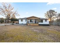 Charming home featuring a covered front porch and carport, set on a spacious lot at 4605 Doss Cir, Powder Springs, GA 30127