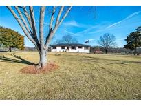 Charming ranch-style home with a large front yard and mature trees on a sunny day at 3241 Broadnax Mill Rd, Loganville, GA 30052