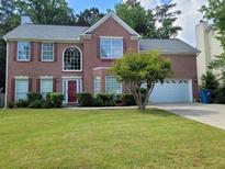Charming brick home with a well-manicured lawn and a two-car garage, blending traditional elegance and curb appeal at 5070 Saddle Bridge Ln, Alpharetta, GA 30022