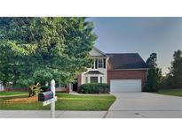 Two-story brick home with a two-car garage, lawn and landscaping at 6170 Winston Trce, Mcdonough, GA 30252