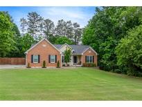 Charming brick home featuring a well-manicured lawn and inviting front entrance at 3982 Ivory Gables Pl, Buford, GA 30519